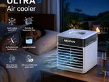 an air cooler sitting on top of a bed next to a lamp