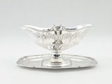 a silver plate with a bird on it and a tray underneath it