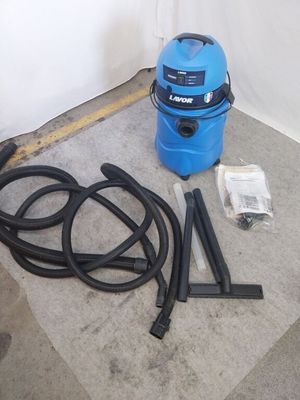 un aspirateur bleu posé par terre à côté d'un tuyau
