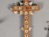 a cross made out of buttons on the wall next to a pair of scissors