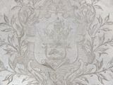 a silver plate with a design of a coat of arms on it