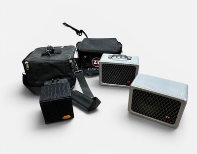three black and silver amps sitting next to each other on a white surface