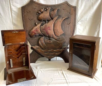 une plaque en bois sur laquelle est représenté un bateau, à côté d'une boîte en bois