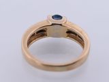 a close up of a gold ring with a blue sapphire stone