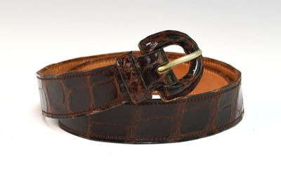 a close up of a brown belt with a gold buckle