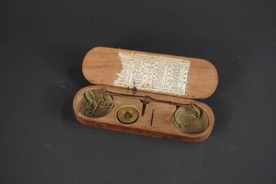 Peson dans sa boite avec quelques poids incomplet.