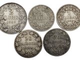 un ensemble de cinq pièces d'argent portant les noms de différents pays