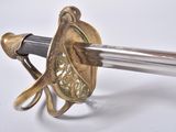 a close up of a sword on a white surface