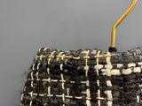 a black and white purse with a yellow handle