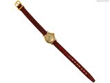 une photo d'une montre en or avec un bracelet en cuir marron