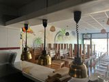 tables and chairs in a restaurant with a mural on the wall