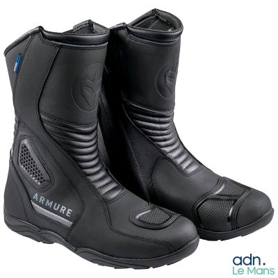 un gros plan sur une paire de bottes de moto noires sur fond blanc