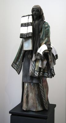 statue d'une femme tenant une pile de livres, posée sur un socle noir