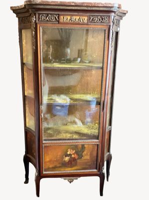a cabinet with a glass door that has a painting on it