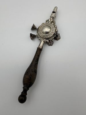 a silver spoon with a wooden handle on a white surface