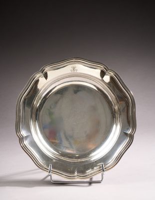 an antique silver plate on a stand on a white surface