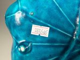 a blue vase sitting on a table with a tag on it