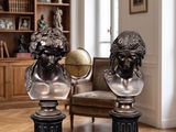 deux statues représentant un homme et une femme assis sur une table