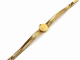 a close up of a gold watch on a white surface
