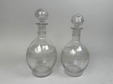 pair of clear glass decante bottles with etched designs