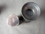 two silver cups sitting on a table next to each other