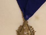 a medal with a blue ribbon around it on a table