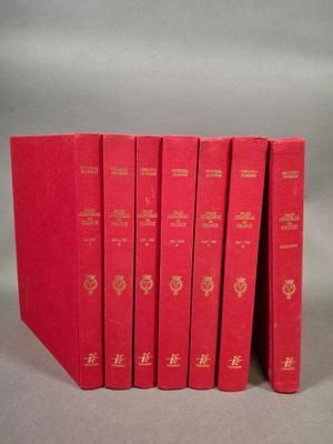 six livres rouges sont empilés les uns sur les autres sur une surface grise