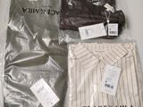 three pieces of clothing wrapped in plastic bags on a table