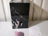 a black marble box sitting on top of a white table