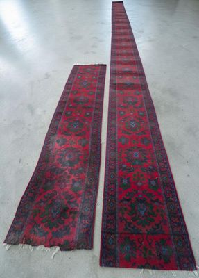 two red rugs sitting on top of a white floor next to each other