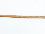 a wooden stick with a wooden handle on a white surface