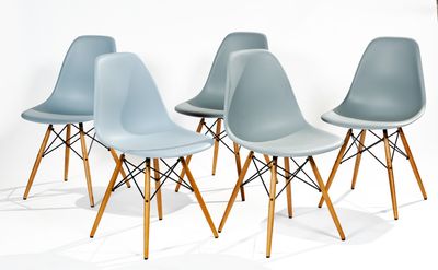four blue chairs with wooden legs are lined up against a white wall