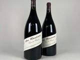 two bottles of red wine sitting next to each other on a table