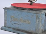 a small blue and red gramophone on a white surface