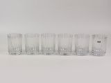 six verres à eau en verre transparent alignés sur une surface blanche