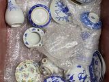 a lot of blue and white dishes and cups in a box