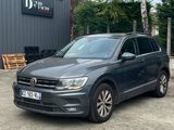 a grey volkswagen tigua parked in front of a building