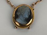 a close up of a necklace with a picture of a woman on it