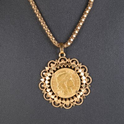 Gros plan sur un collier orné d'une pièce de monnaie en or