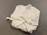 une serviette enveloppée dans une serviette blanche, posée sur une surface grise