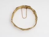 an image of a gold bracelet with a chain hanging from it