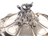 a silver plate with a bird on top of it