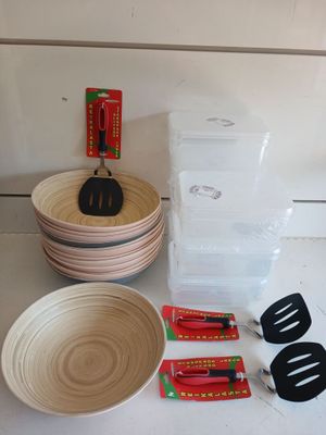 many bowls, spatulas, and other kitchen utensils on the counter