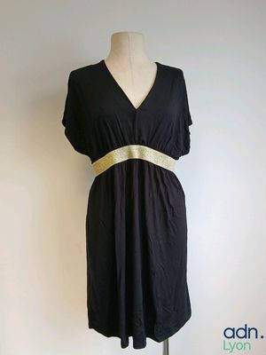 black dress with a gold belt on a mannequin stand