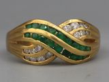 an image of a gold ring with emerald and diamonds