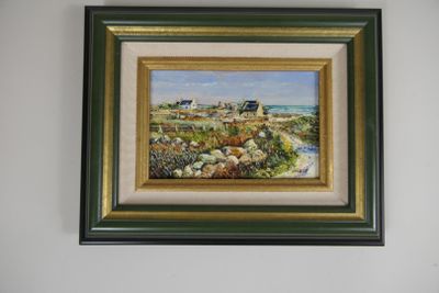framed oil painting of a beach scene with a house in the distance