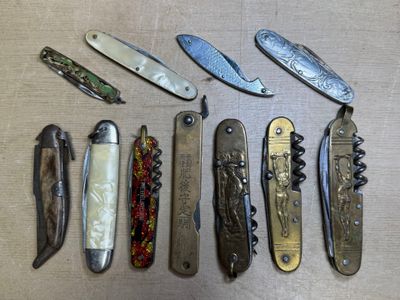 de nombreux types de couteaux de poche posés sur la table