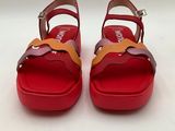 the red and yellow sandals are on a white surface