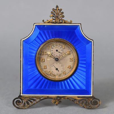 a small blue clock with a gold frame on a table