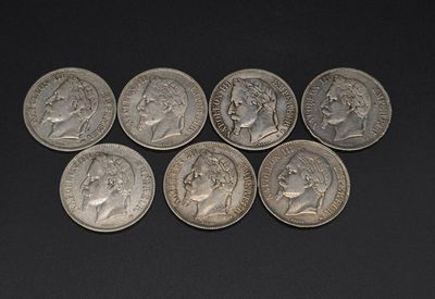 six different types of silver coins on a black surface